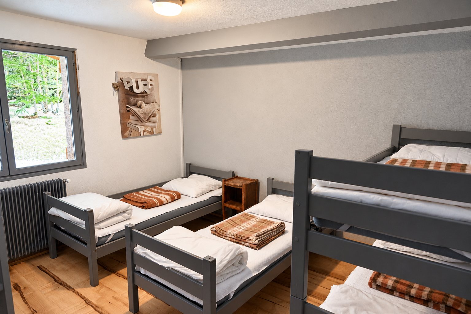 Chambre simple avec lits superposés gris et couvertures à carreaux