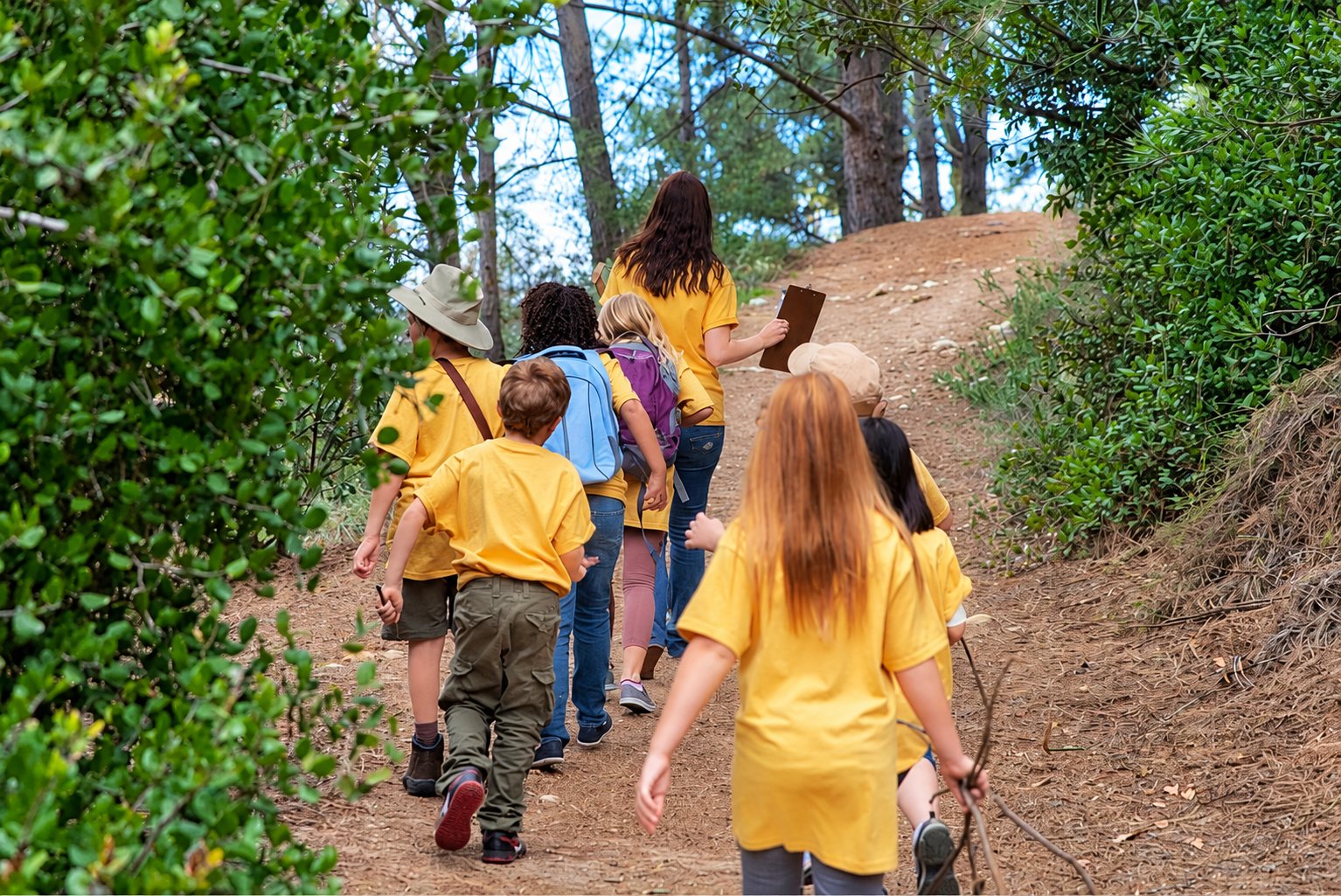 Groupe d’enfants en t-shirts jaunes sur un sentier de forêt