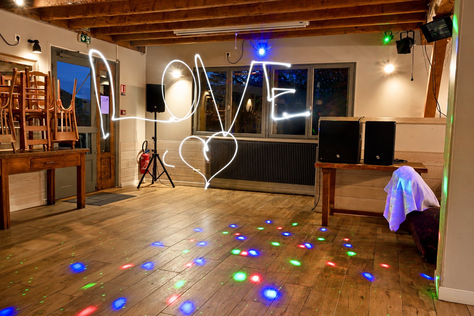 Salle de fête éclairée de lumières colorées, avec une inscription lumineuse