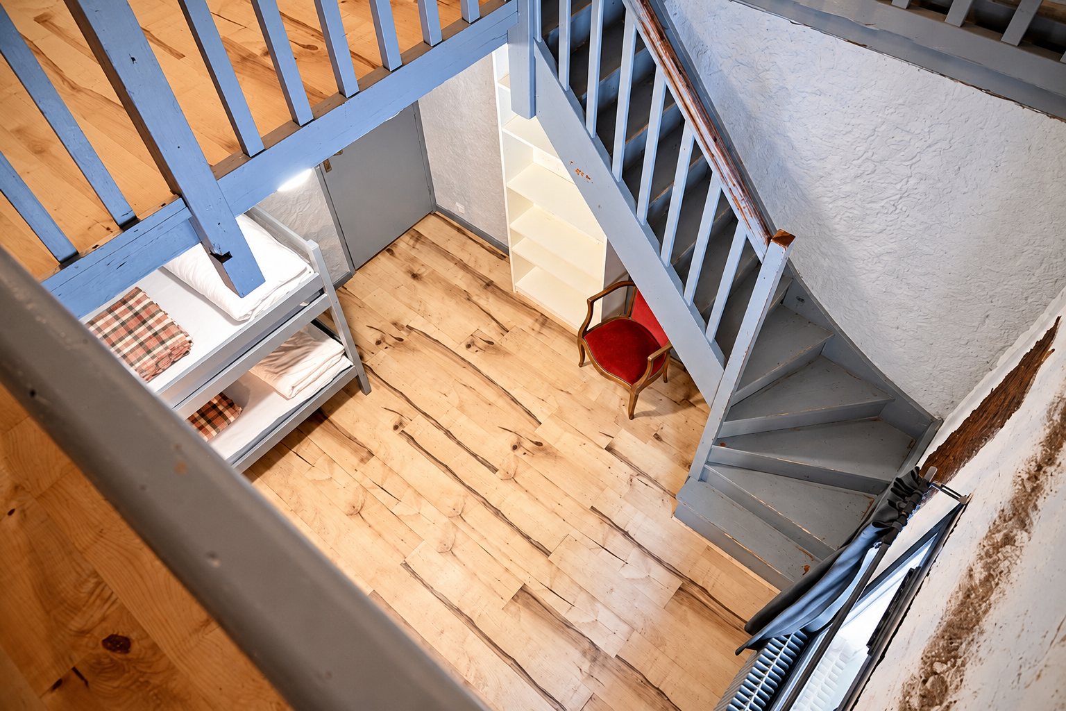 Vue plongeante sur un escalier bleu et un parquet clair